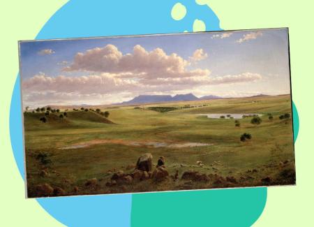 A green field with hills and a lake